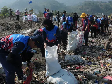 Warga bersama anggota TNI, Polri, pemuda karang Taruna melakukan aksi membersihkan sampah di Pantai Loji, Desa Sangrawayang, Pelabuhan Ratu, Sukabumi, Jawa Barat, Jumat (6/10/2023). (merdeka.com/Imam Buhori)