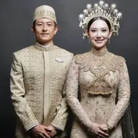 Gaya busana resepsi Athina Papadimitriou dan Rio Haryanto begitu menawan. Keduanya mengenakan baju adat peranakan Melayu yang begitu megah. [Foto: Instagram/ The Bridestory]