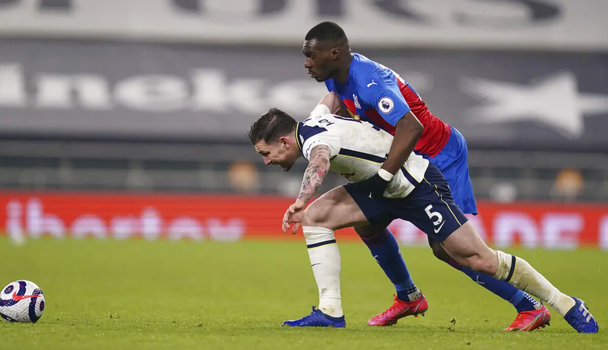 Pemain Tottenham Hotspur Pierre-Emile Hojbjerg (kiri) memperebutkan bola dengan pemain Crystal Palace Christian Benteke pada pertandingan Liga Inggris di Stadion Tottenham Hotspur, London, Inggris, Minggu (7/3/2021). Tottenham Hotspur melumat Crystal Palace 4-1. (John Walton/Pool via AP)