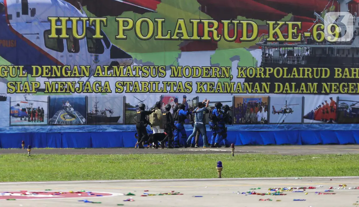 Anggota Polairud menggelandang penjahat saat simulasi penangkapan atau pengungkapan transaksi narkoba saat perayaan HUT ke-69 Polairud di Mako Polairud, Pondok Cabe, Tangerang, Rabu (4/12/2019). Dalam simulasi tersebut Polairud mengerahkan helikopter hingga anjing K9. (Liputan6.com/Faizal Fanani)
