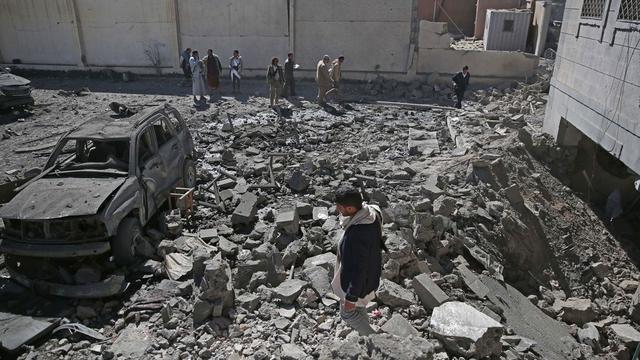 Sejumlah warga mengamati reruntuhan pusat penahanan Houthi yang diserang pasukan koalisi Saudi dari udara di Sanaa (13/12/2017).