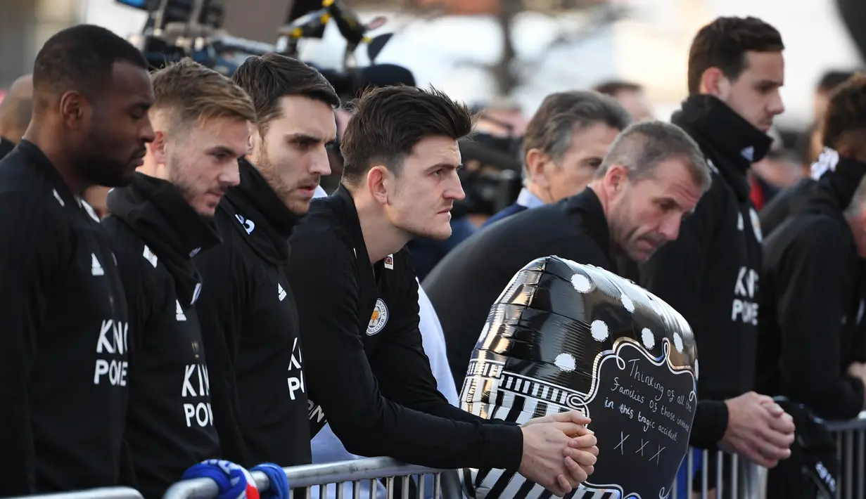 Pemain Leicester City, Harry Maguire (tengah) bersama Matty James, James Maddison, dan Wes Morgan memberi penghormatan atas meninggalnya pemilik Leicester City Vichai Srivaddhanaprabha di luar Stadion King Power, Inggris, Senin (29/10). (Paul Ellis/AFP)