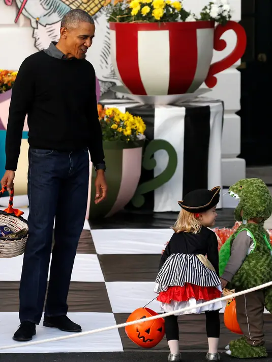 Presiden Barack Obama saat akan membagikan coklat dan permen ke anak-anak pada perayaan Halloween di Gedung Putih, Washington, Senin (31/10). Sebanyak 4.000 orang diperkirakan mengunjungi White House untuk merayakan Hallowen. (REUTERS / Jonathan Ernst)