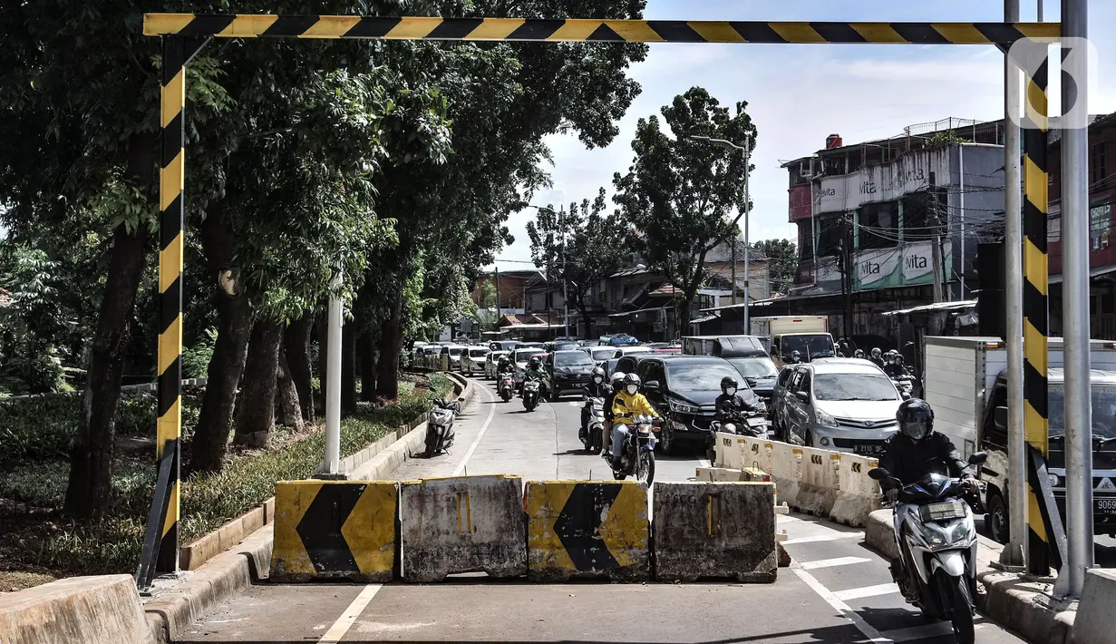Pengendara motor menerobos separator yang menutup akses jalan layang atau flyover tapal kuda Lenteng Agung, Jakarta, Minggu (28/2/2021). Minimnya pengawasan menyebabkan banyak pengendara sepeda motor nekat menerobos flyover tapal kuda Lenteng Agung yang masih ditutup. (merdeka.com/Iqbal S Nugroho)