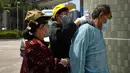 Pasien mengenakan pakaian pelindung setelah tiba di ruang tunggu sementara di luar Caritas Medical Center, Hong Kong, Rabu (2/3/2022). Beberapa orang terpaksa menunggu di luar rumah sakit karena saat ini sedang kelebihan beban dengan kemungkinan pasien terinfeksi COVID. (AP Photo/Kin Cheung)