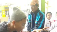 Para siswa SDN 1 Bayongbong, Garut nampak asik saat pelaksanaan cukur rambut gratis saat Hari Anak Sedunia (Liputan6.com/Jayadi Supriadian)