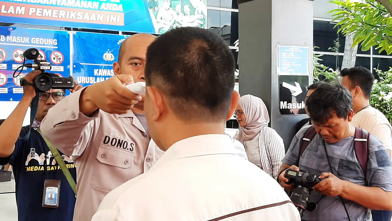 Polda Metro Jaya mengecek suhu tubuh pengunjung yang hendak mengurus surat-surat kendaraan, Selasa (10/3/2020).