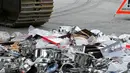Sebuah alat berat bersiap menggilas panci palsu dan peralatan dapur yang disita Badan Bea Cukai Swiss di Jenewa, Swiss, Selasa (16/6/2015). (REUTERS/Pierre Albouy)