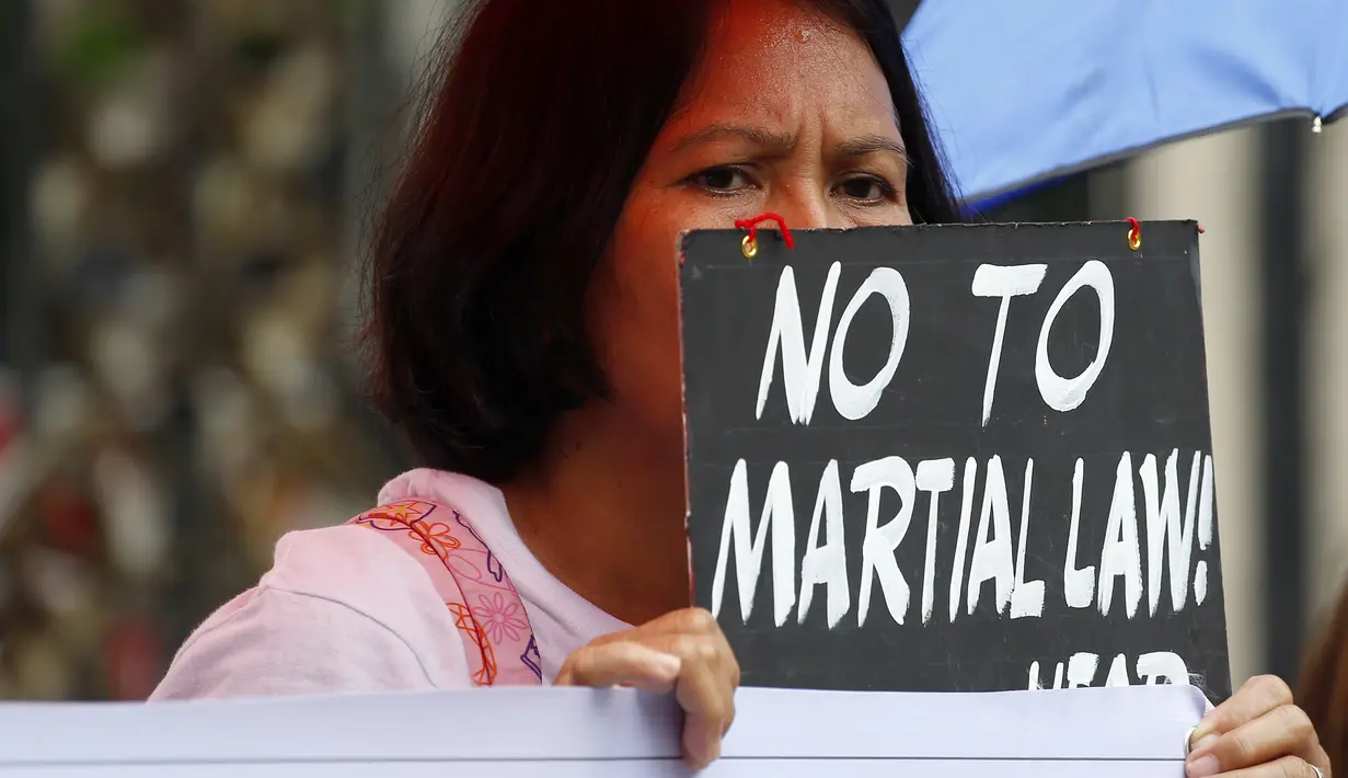 Sejumlah orang menggelar aksi protes terhadap  deklarasi Darurat Perang oleh Presiden Duterte di wilayah selatan Mindanao, Manila, Filipina, Kamis (8/6). deklarasi tersebut menurut mereka hanya akan menimbulkan pelanggaran HAM. (AP Photo / Bullit Marquez)