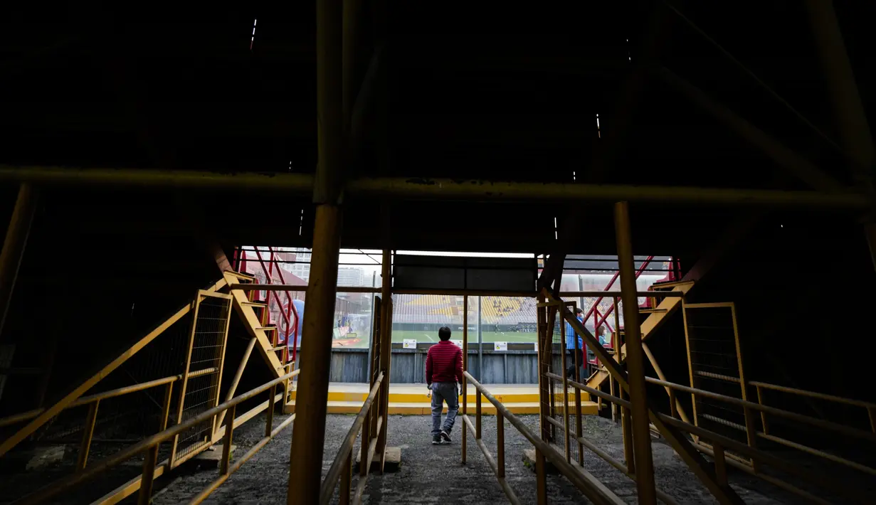 Seorang penggemar klub Union Espanola memasuki stadion Santa Laura untuk menyaksikan pertandingan di Santiago, Chile, Sabtu (14/8/2021). Setelah lebih dari satu tahun lockdown, penggemar diizinkan kembali ke stadion di tengah protokol kesehatan dan jarak sosial yang ketat. (AP/Esteban Felix)