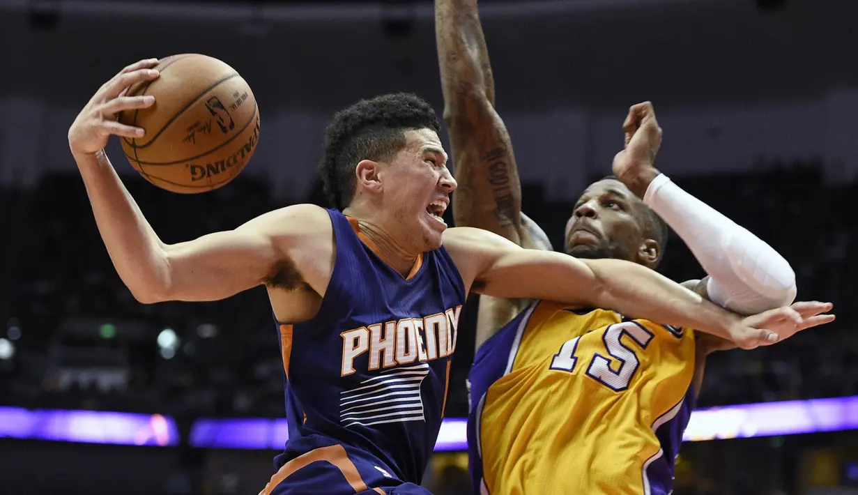 Pemain Phoenix Suns, Brandon Knight (kiri) berusaha melewati hadangan pemain Los Angeles Lakers, Thomas Robinson pada laga NBA preseason basketball game di Anaheim, California (22/10/2016). (AP/Kelvin Kuo)