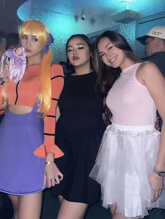 Anya Geraldine tampil mengenakan crop orange lengan panjang bergaris hitam dipadukan overall ungu senada dengan pitanya yang disematkan di rambut kuncir dua blondenya. Caitlin Halderman cosplay jadi Barbie dengan tanktop punk dan rok tutu putih. [@anissaica]