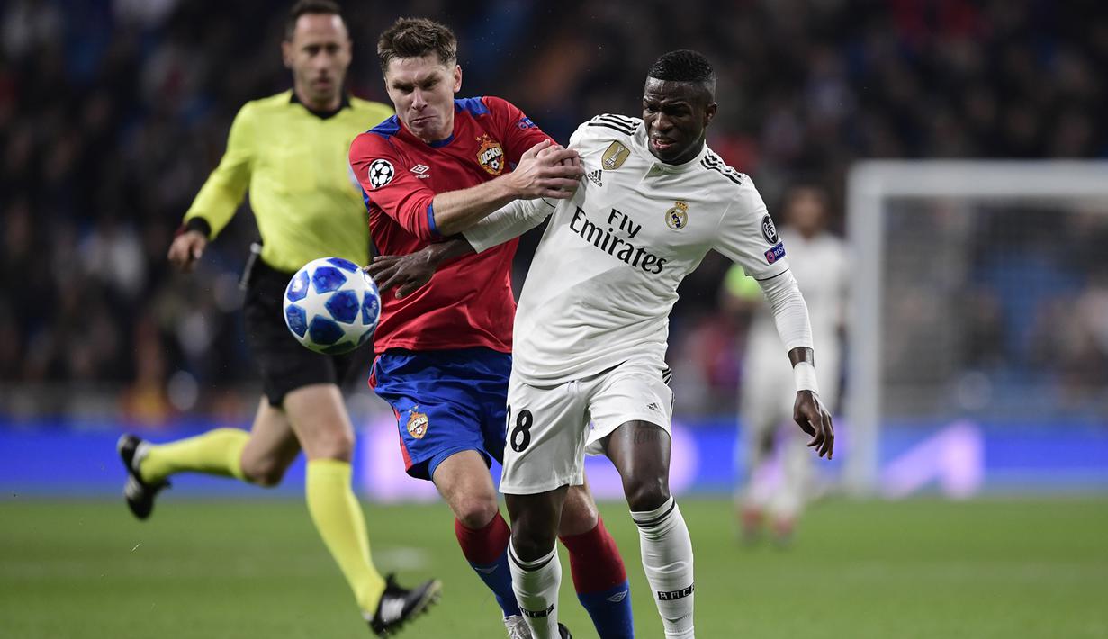 Bek CSKA Moskow, Kirill Nababkin, berebut bola dengan striker Real Madrid, Vinicius Junior, pada laga Liga Champions di Stadion Santiago Bernabeu, Madrid, Rabu (12/12). Madrid kalah 0-3 dari CSKA. (AFP/Javier Soriano)