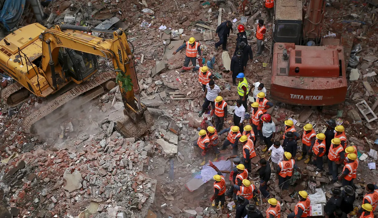 Sejumlah petugas  sibuk mencari korban yang terjebak di  reruntuhan bangunan di Mumbai, India, Selasa (4/8/2015). Bangunan tersebut runtuh karena kondisinya yang sudah tak layak pakai dan menewaskan 11 orang.(REUTERS/Danish Siddiqui)