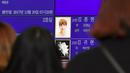 Para fans memandangi foto Jonghyun SHINee di papan elektronik di luar rumah duka Seoul Asan Hospital, Korea Selatan, Selasa (19/12). Jonghyun SHINee dikabarkan meninggal dunia karena bunuh diri menghirup karbon monoksida berlebih. (JUNG Yeon-Je / AFP)
