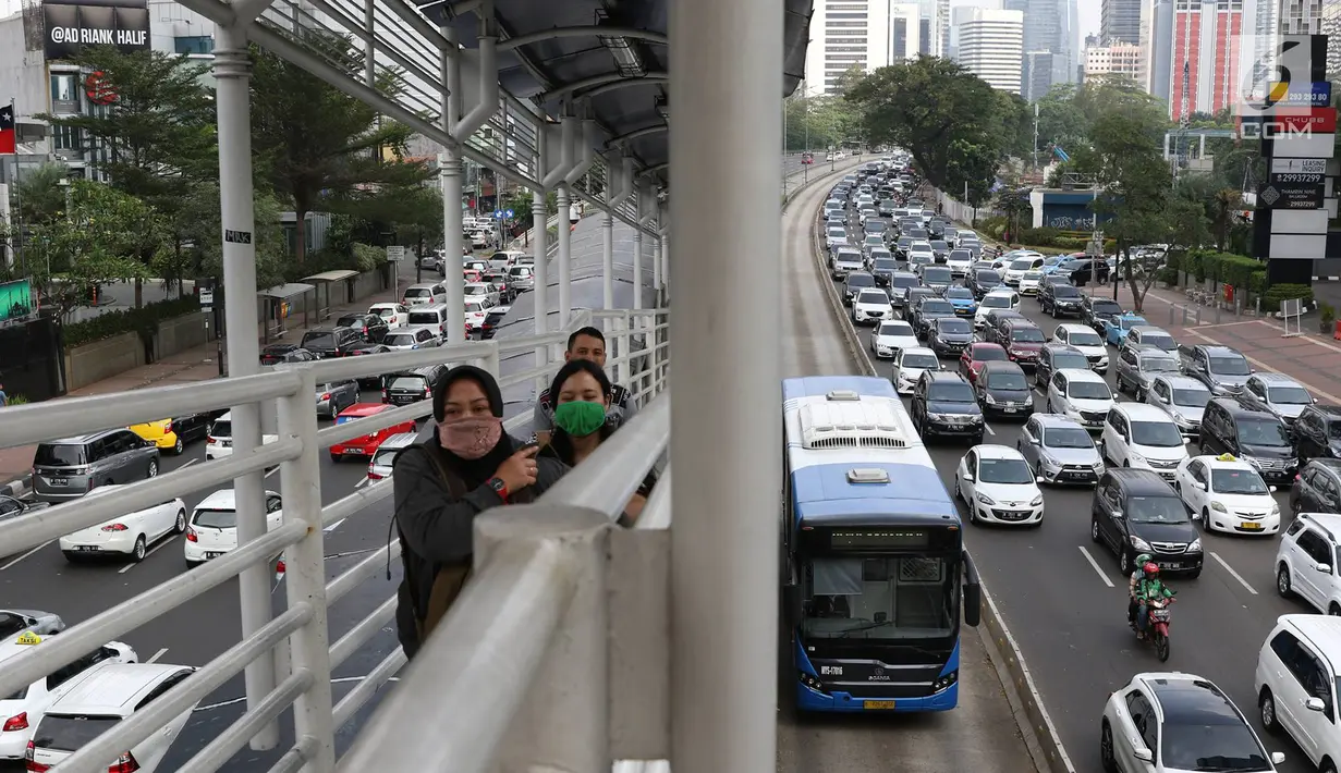 Calon penumpang berjalan di halte di Jalan Sudirman, Jakarta, Jumat (23/6). Polda Metro Jaya tidak memberlakukan pengendalian lalu lintas ganjil-genap di beberapa jalan protokol Jakarta dari 23 Juni hingga 2 Juli 2017. (Liputan6.com/Immanuel Antonius)