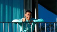Cristiano Ronaldo yang terjangkit COVID-19 tampak semringah menyaksikan rekan-rekannya di timnas Portugal berlatih dari balkon kamar hotelnya, Selasa (13/10/2020) (AFP/Diogo Pinto)