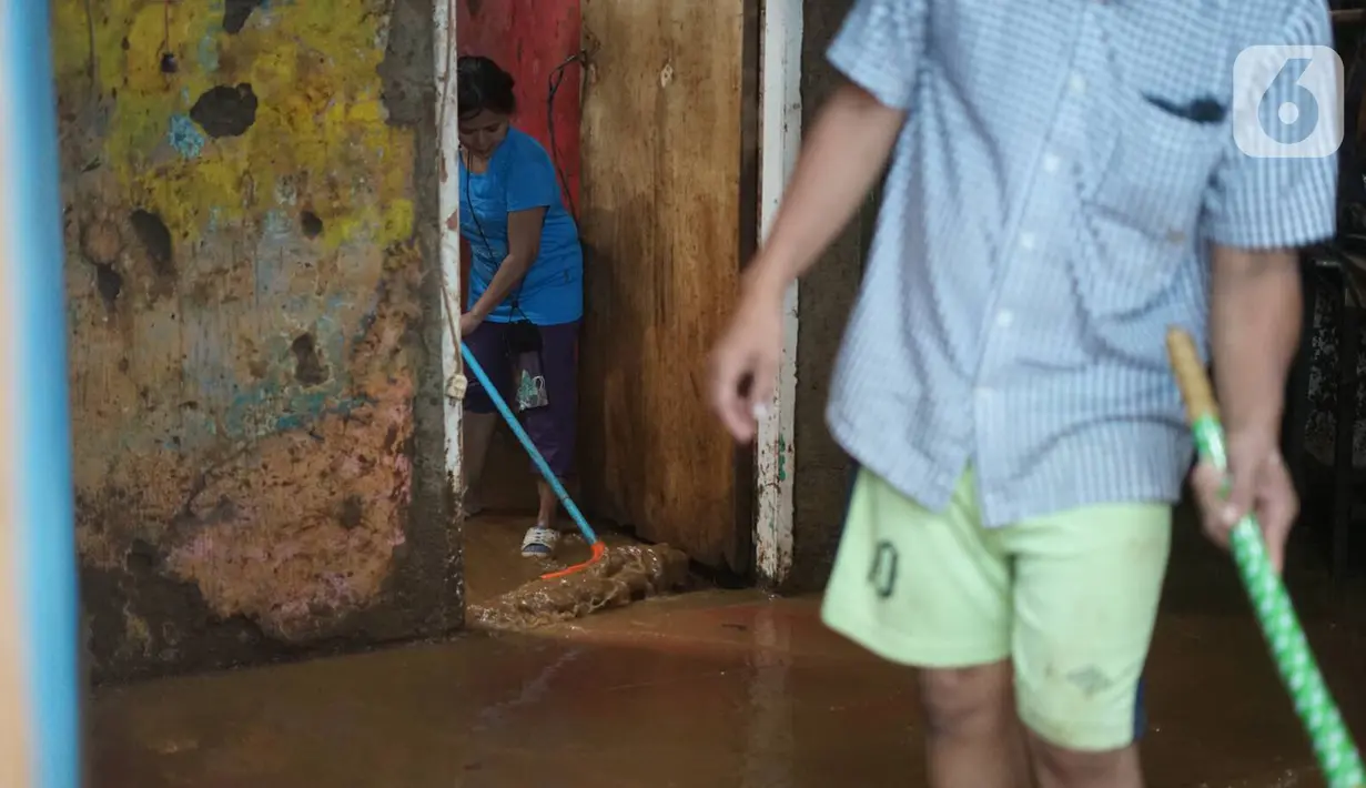 Warga membersihkan banjir yang merendam kawasan Rawajati, Jakarta Selatan, Sabtu (8/2/2020). Hujan yang terjadi semalaman menyebabkan Sungai Ciliwung kembali meluap hingga membuat rumah warga di kawasan tersebut terendam air setinggi 50 cm hingga 1 m. (Liputan6.com/Immanuel Antonius)
