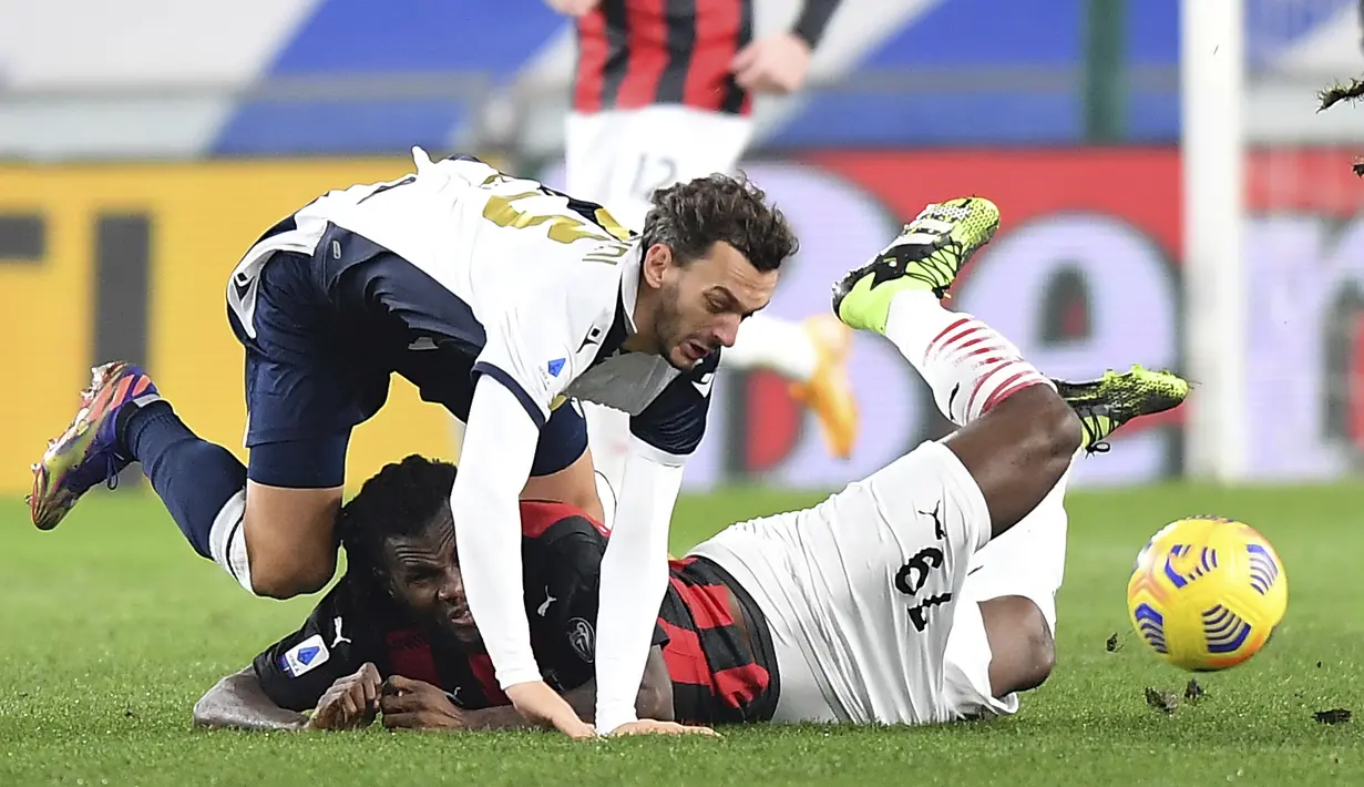 Gelandang AC Milan, Franck Kessie berebut bola dengan pemain Sampdoria, Manolo gabbiadini pada pertandingan lanjutan Liga Serie A Italia di Stadion Genoa Luigi Ferraris, Italia, Senin (7/12/2020). AC Milan menang tipis atas Sampdoria 2-1. (Tano Pecoraro/LaPresse via AP)