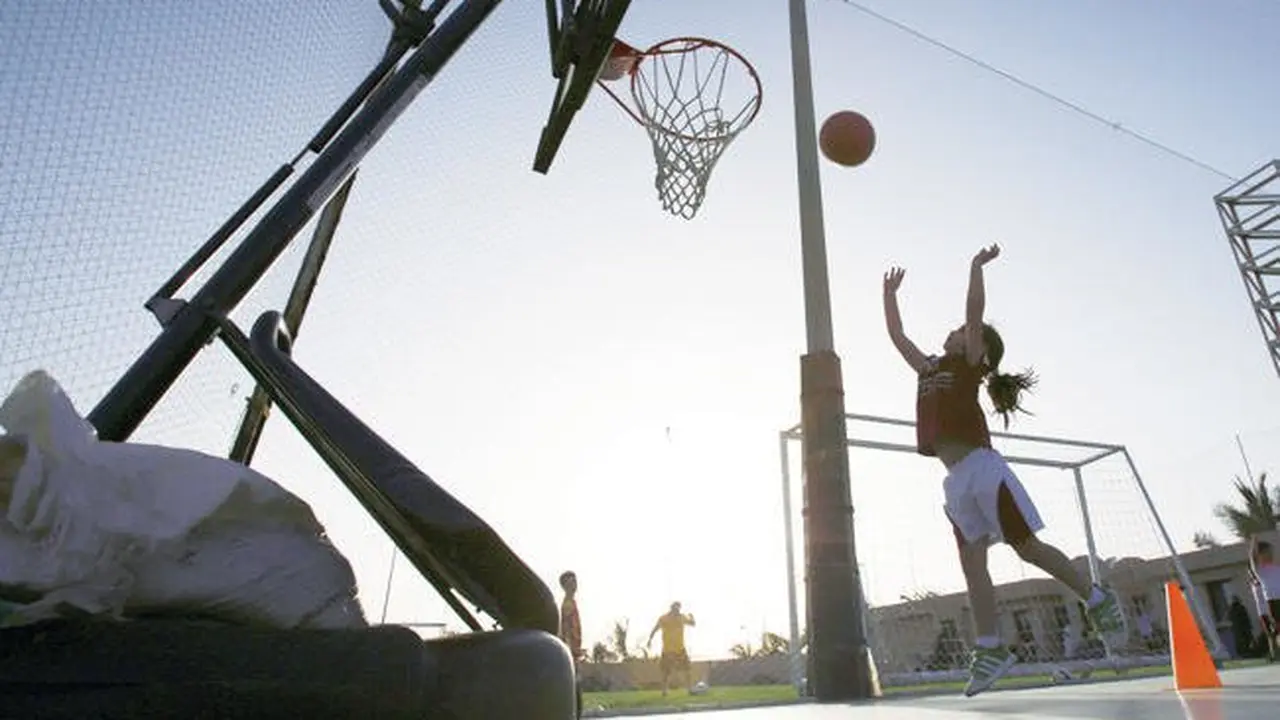 Seorang perempuan bermain basket di lapangan olahraga pribadi. (AP)