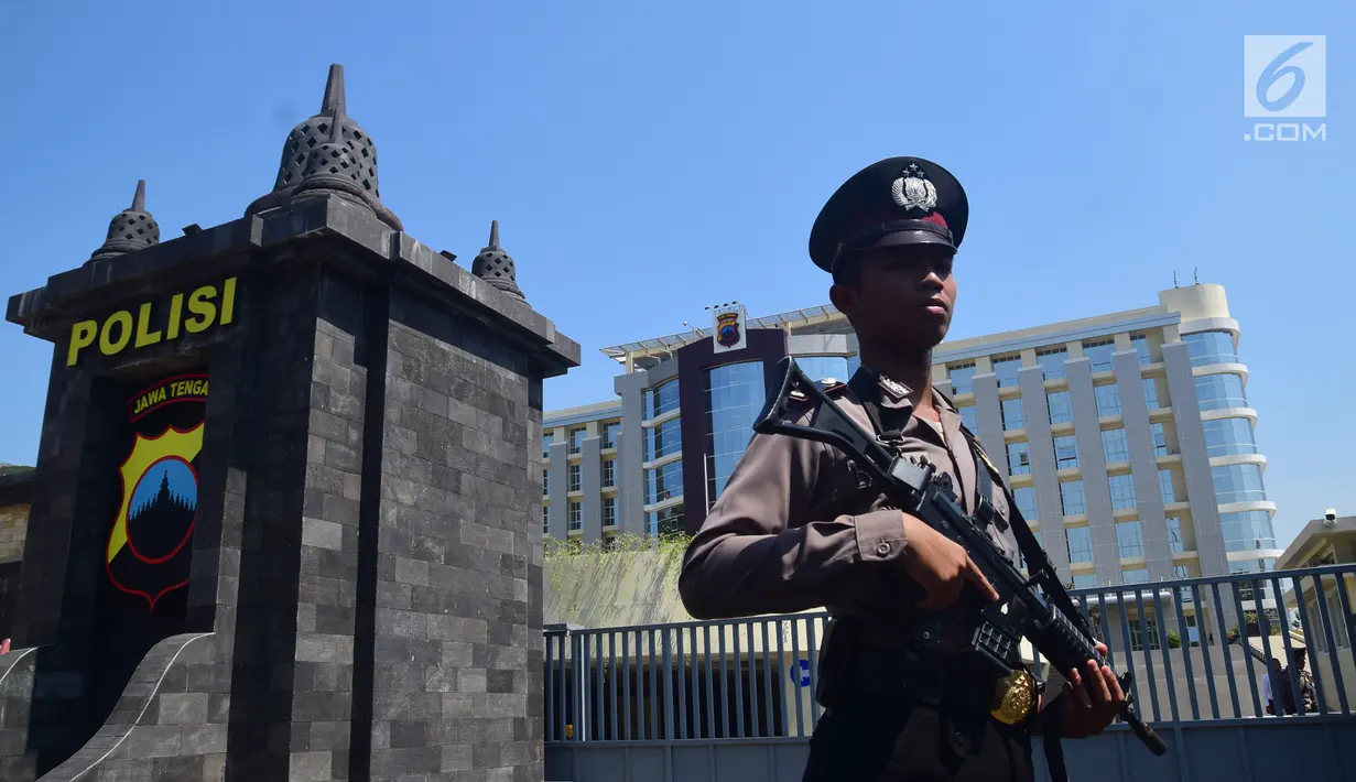 Anggota polisi bersenjata lengkap melakukan penjagaan di gerbang pintu masuk Mapolda Jawa Tengah, Kota Semarang, Senin (14/5).Tak ingin kecolongan, Mapolda Jateng memperketat pengamanan menyusul aksi teror bom yang bertubi-tubi. (Liputan6.com/Gholib)