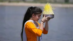 Seorang Umat Hindu bersiap untuk membenamkan bibit jelai sebagai persembahan saat Festival Navratri di Sungai Tawi, Jammu, India, 10 April 2022. Sesaji tersebut dibuat sebagai bagian dari ritual menandai berakhirnya festival selama sembilan hari. (AP Photo/Channi Anand)