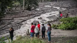 Sejumlah warga melihat aliran lahar dingin Gunung Agung di Karangasem, Bali (29/11). Ribuan turis diperkirakan akan meninggalkan Bali pada 30 November menyusul penutupan bandara akibat Gunung Agung Meletus. (AFP Photo/Juni Kriswanto)