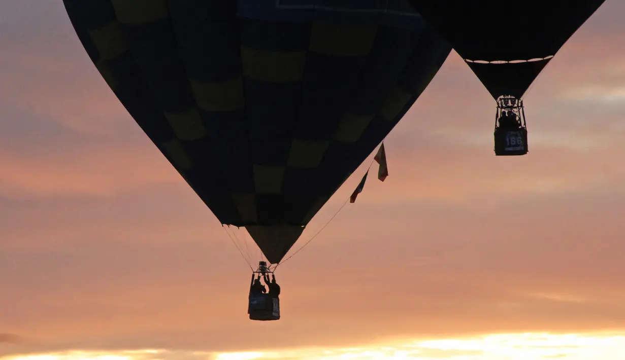 Pemandangan balon udara yang mengangkasa selama Festival Balon Internasional XVIII di Leon, Meksiko pada 18 November 2018. Sekitar 200 balon udara dari 23 negara terbang di atas bendungan Palote. (Photo by MARIO ARMAS / AFP)
