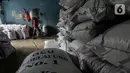 Pekerja melakukan bongkar muat kedelai yang baru tiba di gudang penyimpanan di Kawasan Kebayoran Lama, Jakarta, Kamis (14/1/2021). Harga diproyeksi mulai turun pada Juni seiring membaiknya produksi di negara-negara Amerika Selatan. (Liputan6.com/Johan Tallo)
