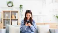 Ilustrasi wanita muda belanja online via smartphone. (Shuttestock/Monster Ztudio)