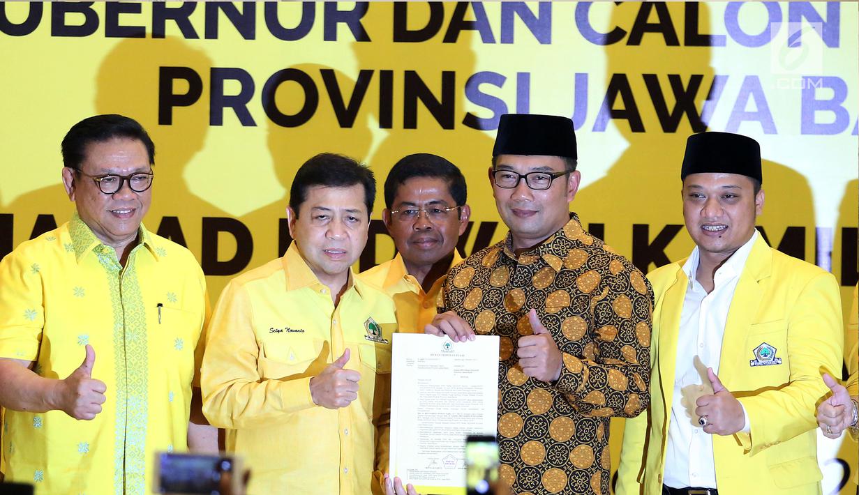 Ketua Umum Golkar Setya Novanto, Ridwan Kamil dan Daniel Muttaqien berfoto bersama menunjukan surat keputusan (SK) pengusungan usai pengumuman Calon Gubernur dan Wakil Gubernur Jawa Barat di DPP Golkar, Jakarta, Kamis (9/11). (Liputan6.com/Johan Tallo)