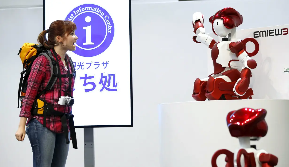 Petugas memperagakan robot humanoid 'EMIEW 3' yang dapat membantu turis dari negara asing di Tokyo, Jepang, (8/4). Robot ini dikembangkan untuk memberikan layanan dan bimbingan yang diperlukan di toko-toko dan fasilitas umum. (REUTERS/Issei Kato)