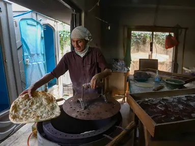 Seorang pencari suaka memasak roti di tempat penampungan sementara, Kalideres, Jakarta Barat, Kamis (15/8/2024). (merdeka.com/Arie Basuki)