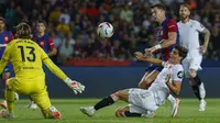 Striker Barcelona, Robert Lewandowski (kanan) melepaskan tendangan yang berusaha diblok gelandang Sevilla, Juanlu Sanchez pada laga pekan ke-8 Liga Spanyol 2023/2024 di Olympic Stadium, Montjuic, Barcelona, Sabtu (30/9/2023) dini hari WIB. (AP Photo/Joan Monfort)