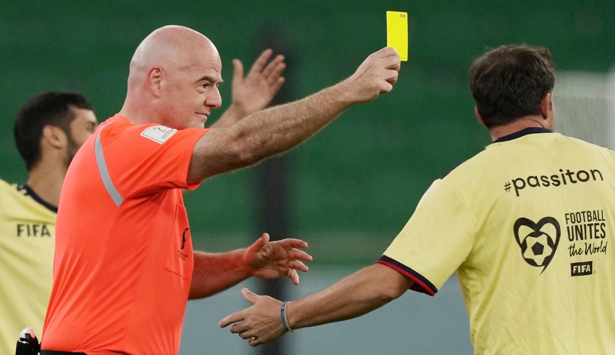 Presiden FIFA, Gianni Infantino, memberikan kartu kuning kepada Alessandro Del Piero pada laga hiburan jelang semi final Piala Dunia di Stadion Al Thumama, Senin (12/12/2022). (AP Photo/Frank Augstein)