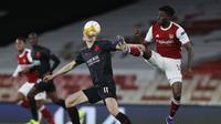 Gelandang Arsenal, Thomas Partey berebut bola dengan pemain Slavia Praha,  Lukas Provod pada pertandingan leg pertama perempat final Liga Europa di Stadion Emirates di London, Jumat (9/4/2021). Arsenal bermain imbang atas Slavia Praha 1-1.  (AP Photo/Alastair Grant)