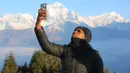 Seorang turis berswafoto di Bukit Poon yang terletak di Distrik Myagdi, Nepal (15/2/2020). Bukit Poon, yang juga dikenal sebagai Poon Hill, merupakan sebuah lokasi di sepanjang rute pendakian di wilayah Annapurna yang populer di kalangan wisatawan. (Xinhua/Zhou Shengping)