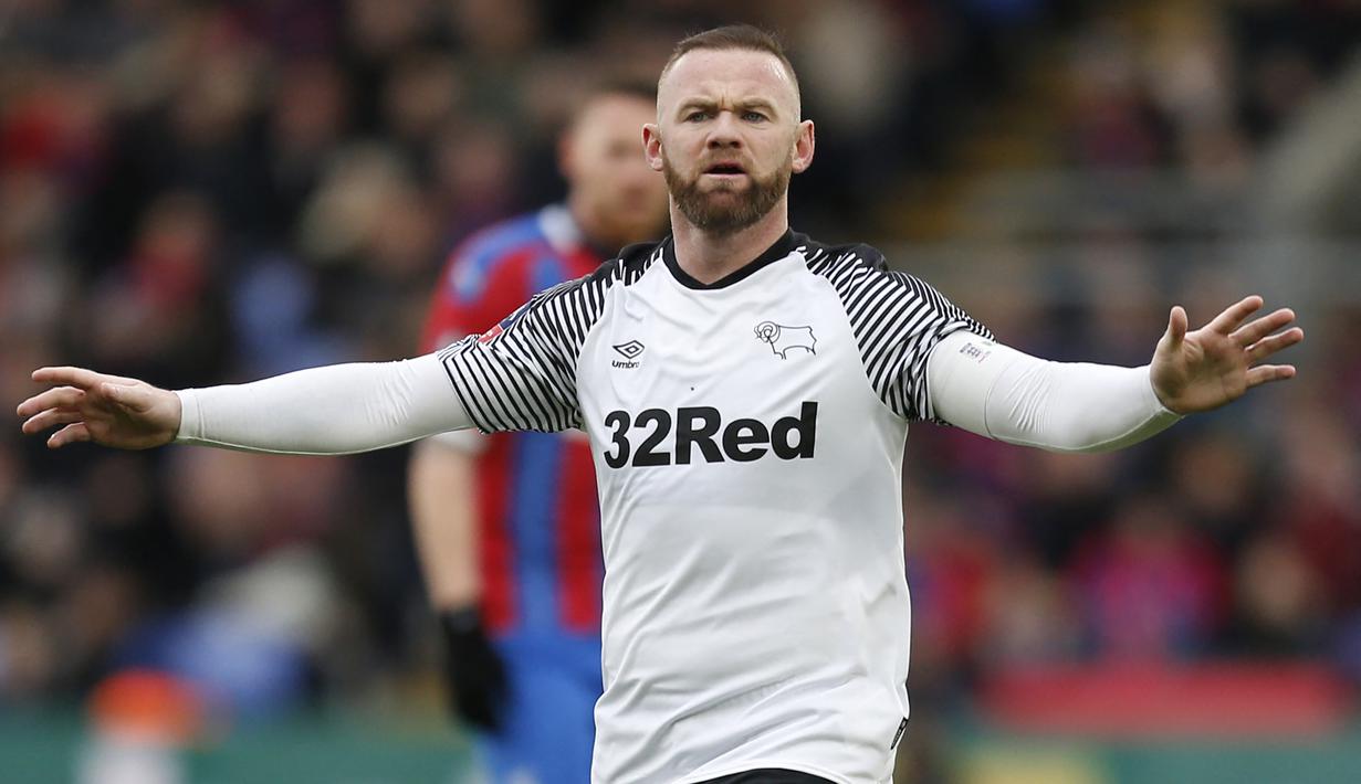 Wayne Rooney. Striker Inggris ini pensiun di Derby County di usia 36 tahun pada 15 Januari 2021. Total tampil dalam 887 laga bersama klub maupun timnas, dengan torehan 366 gol dan 205 assist. Ia pernah mencapai nilai jual tertinggi sebesar 65 juta euro bersama Manchester United. (AFP/Ian Kington)