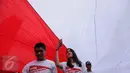 Peserta 'Aksi Kita Indonesia' berjalan di bawah Bendera Merah Putih raksasa yang dibawa berkeliling Bundaran HI, Jakarta, Minggu (4/12). Aksi Kita Indonesia atau Aksi 412 diinisiasi oleh partai-partai pendukung Pemerintah. (Liputan6.com/Fery Pradolo)