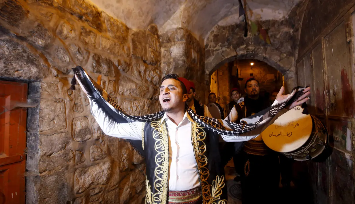 Pemuda Palestina saat membangunkan sahur menggunakan musik tradisional, di permukiman Hebron, Tepi Barat, 23 Juni 2015. Tradisi tersebut dilakukan secara turun-temurun untuk mempererat silaturahmi. (REUTERS/Mussa Qawasma)