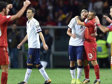 Striker Makedonia, Ilija Nestorovski, memeluk bek Italia, Giorgio Chiellini, pada laga Kualifikasi Piala Dunia 2018 di Stadion Olimpico, Turin, Jumat (6/10/2017). Italia ditahan imbang 1-1 dengan Makedonia. (AP/Alessandro Di Marco)