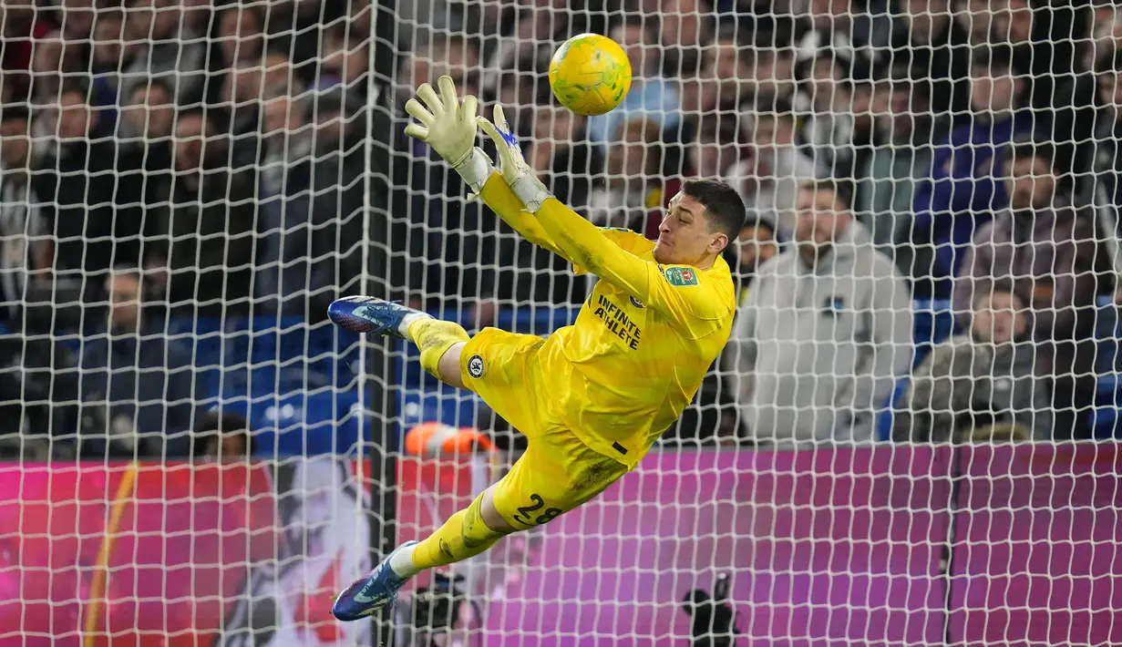 Kiper Chelsea, Djordje Petrovic berhasil memblok eksekusi penalti gelandang Newcastle United, Matt Ritchie saat adu tendangan penalti pada laga perempatfinal Carabao Cup 2023/2024 di Stamford Bridge, London, Rabu (20/12/2023) dini hari WIB. (AP Photo/Kirsty Wigglesworth)