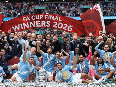Para pemain dan staf Manchester City melakukan selebrasi usai meraih gelar Piala FA setelah mengalahkan Chelsea dengan skor 1-0 di partai final di Wembley Stadium hari Sabtu (16/05/2026) malam WIB. (AFP/Adrian Dennis)