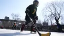 Seorang anak bermain hoki es di kanal yang membeku saat Olimpiade Musim Dingin 2022 hampir berakhir di Beijing pada Sabtu, 19 Februari 2022. (AP Photo/Ng Han Guan)