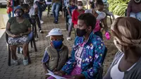 Orang-orang berbaris untuk divaksinasi COVID-19 di Lawley, selatan Johannesburg, Rabu (1/12/2021). Dokter Afrika Selatan mengatakan peningkatan pesat dalam kasus COVID-19 yang dikaitkan dengan varian baru omicron tampaknya hanya menyebabkan gejala ringan. (AP Photo/ Shiraaz Mohamed)