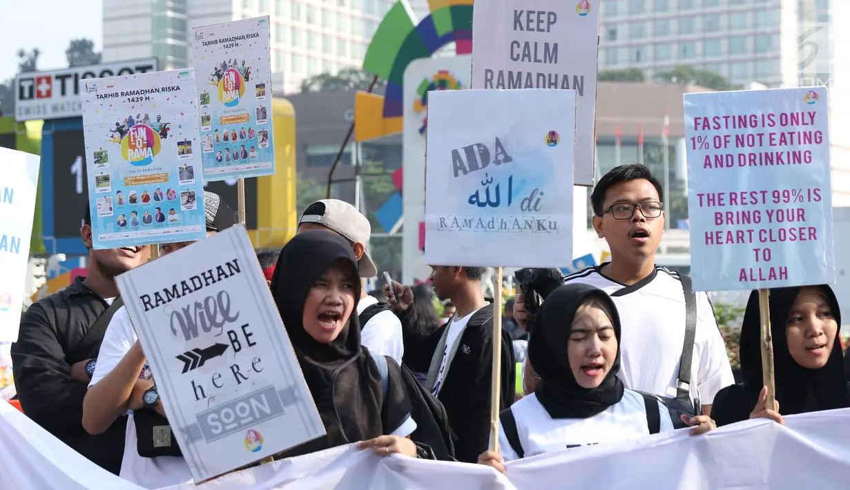 Sejumlah remaja mengangkat tulisan menyambut datangnya bulan Ramadan saat acara Car Free Day di Kawasan Bundaran Hotel Indonesia, Jakarta, Minggu (13/5). Mereka mengajak warga untuk menyambut bulan suci bagi umat muslim. (Liputan6.com/Helmi Fithriansyah)