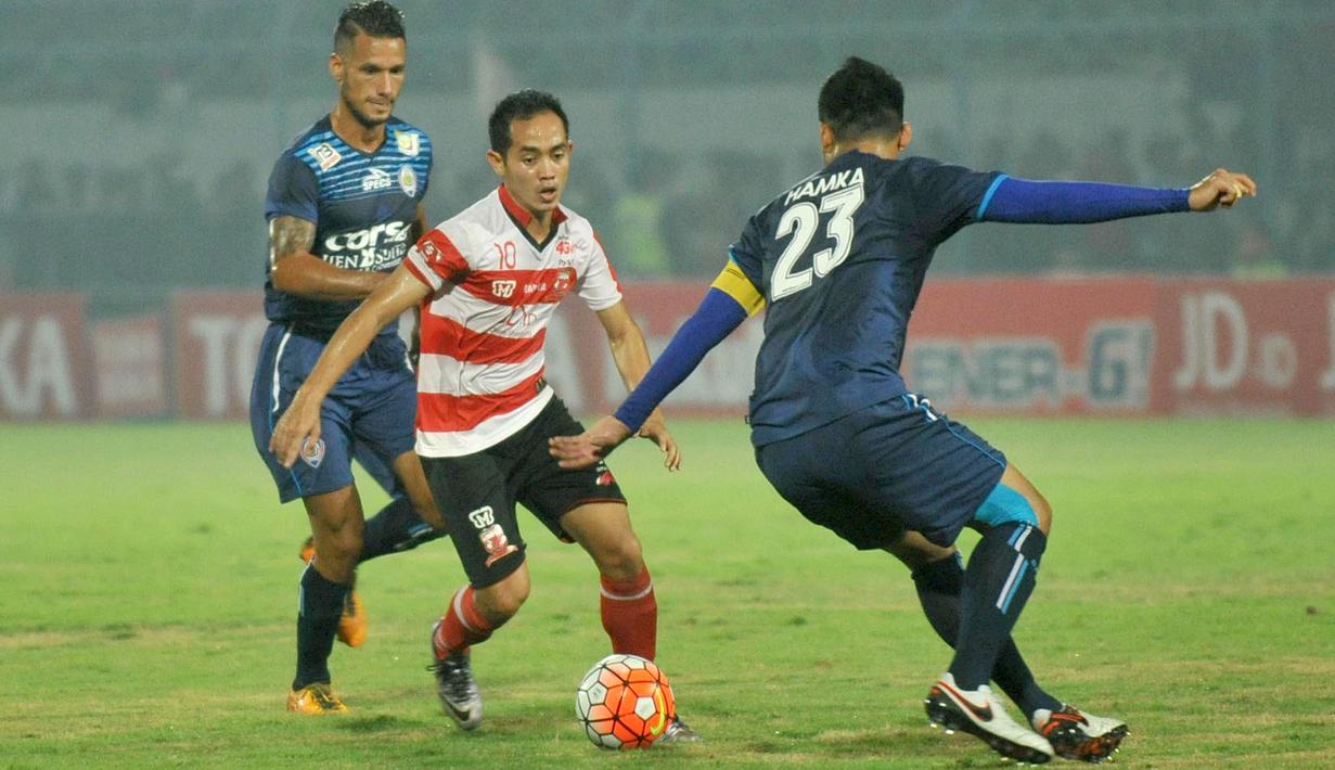Pemain Arema Cronus, Hamka Hamzah (kanan)  dan Rafael Maitimo mengepung pergerakan  pemain Madura United pada laga Torabika Soccer Champions 2016 di Stadion Gelora Bangkalan, Jumat (6/5/2016) WIB. (Bola.com/Fahrizal Arnas)