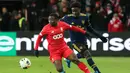 Pemain Arsenal Bukayo Saka (kanan) berebut bola dengan pemain Standard Liege Collins Fai pada pertandingan Grup F Liga Europa di Stadion Maurice Dufrasne, Liege, Belgia, Kamis (12/12/2019). Arsenal juara grup setelah menahan Standar Liege 2-2. (AP Photo/Francois Walschaerts)