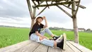 Palantun lagu "Gulu Pedot" ini berhasil beberapa kali trending di YouTube dengan musik videonya. Penampilannya tetap stylish saat berfoto di area sawah. Menggunakan bucket hat berwarna putih, baju kaus hitam dan celana jeans berwarna terang melengkapi gayanya. (Liputan6.com/IG/@esaristyyy_)