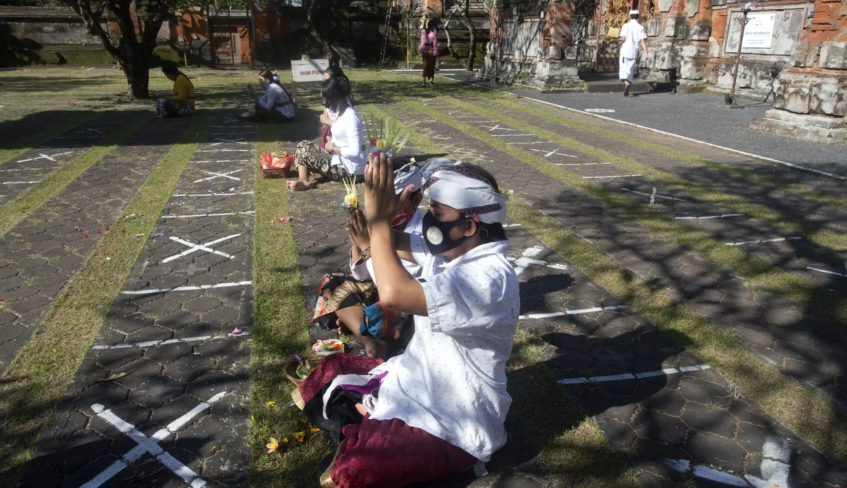 Seorang pria bersembahyang dengan menjaga jarak saat Hari Raya Galungan di sebuah pura di Bali, Rabu (14/4/2021). Perayaan Hari Raya Galungan yang merupakan hari kemenangan kebenaran (Dharma) atas kejahatan (Adharma) itu diikuti umat Hindu dengan menerapkan protokol kesehatan. (AP/Firdia Lisnawati)